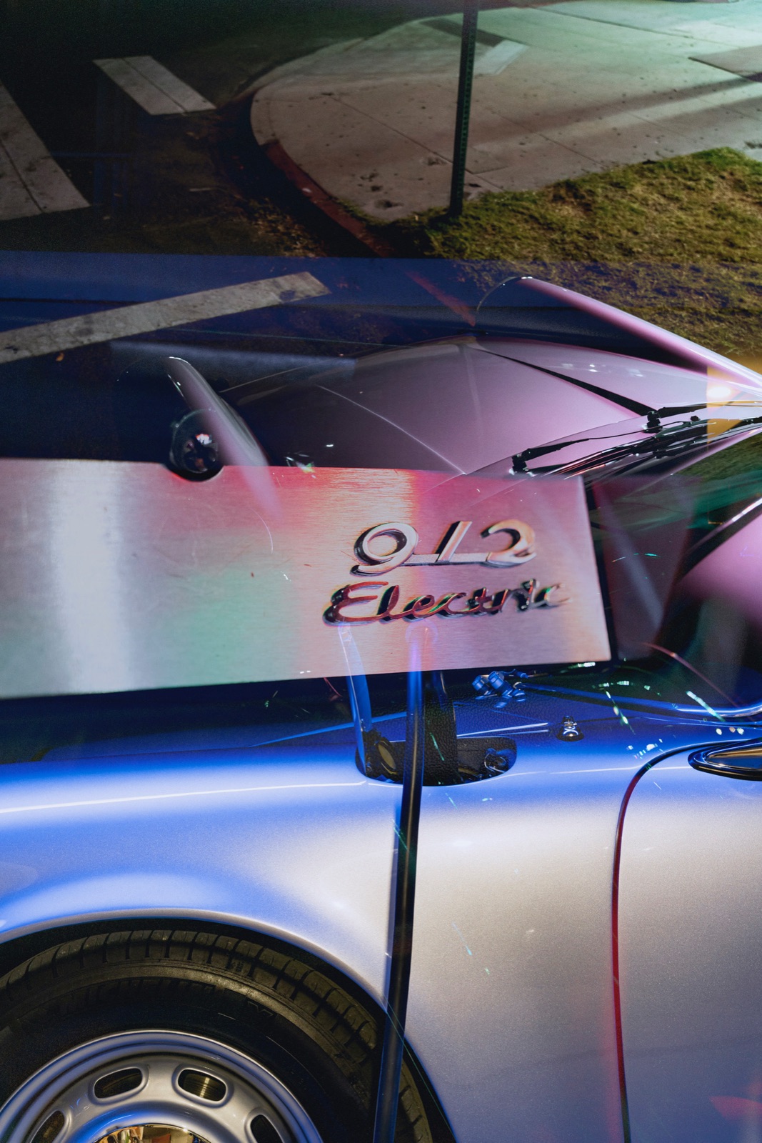 The ‘912 Electric’ badge glowing under neon at night