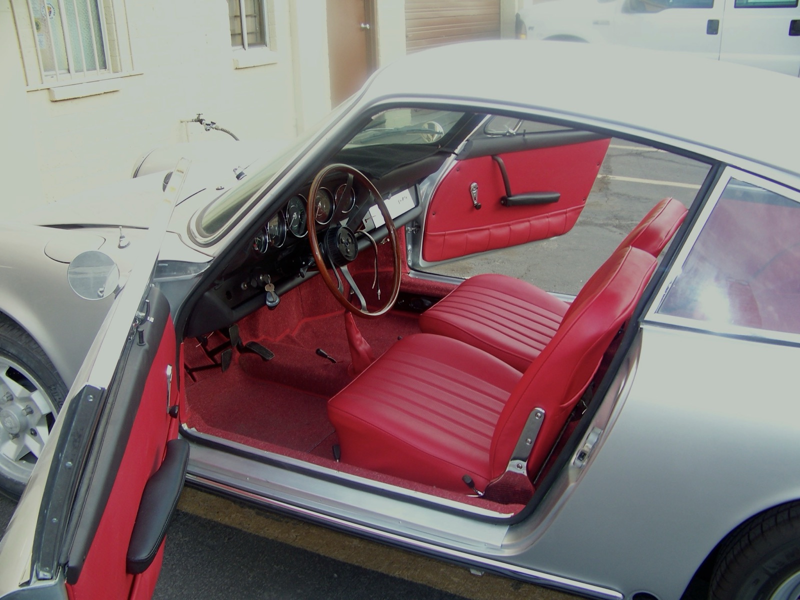 Red leather interior — seats, gauges and restored wooden wheel